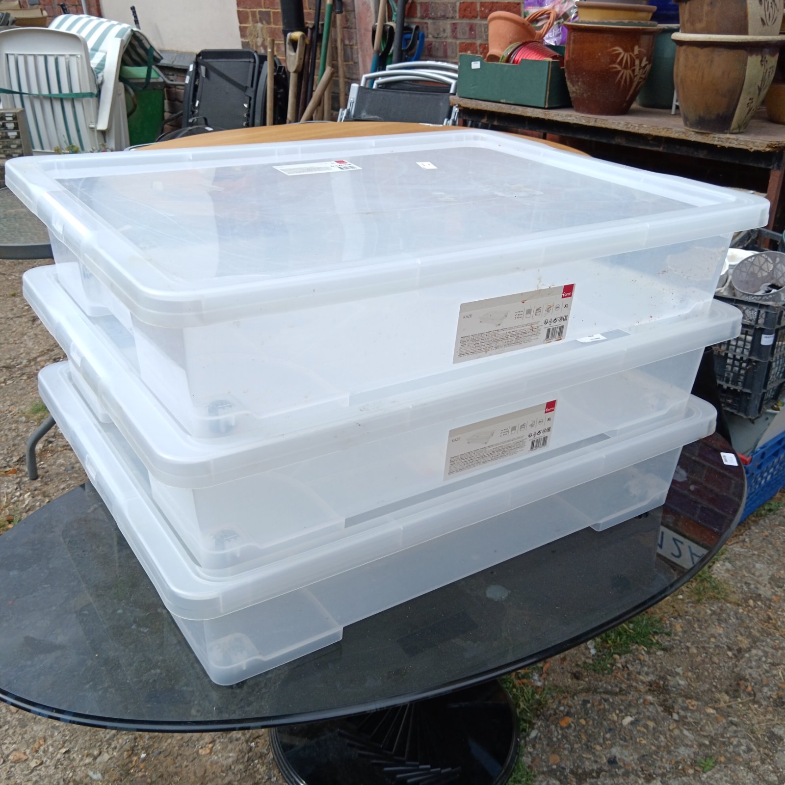 Three large clear plastic Kaze XL storage boxes stacked.