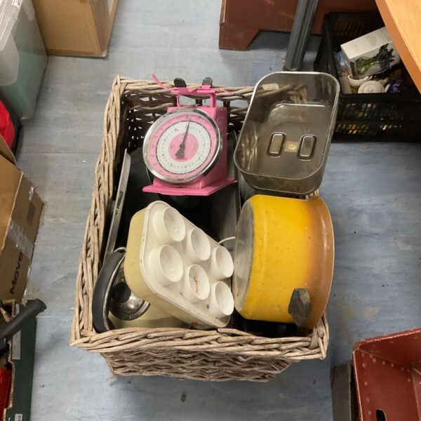 Vintage kitchenware lot with enamel pans and pink scales in a basket.