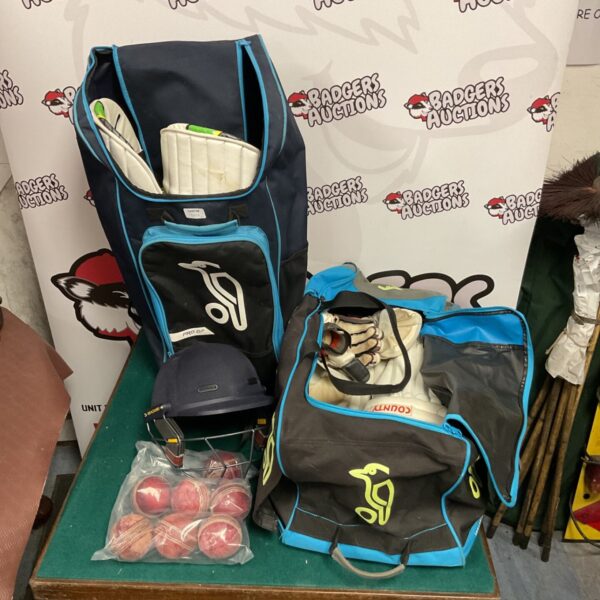 Two Kookaburra cricket bags with pads and balls inside.