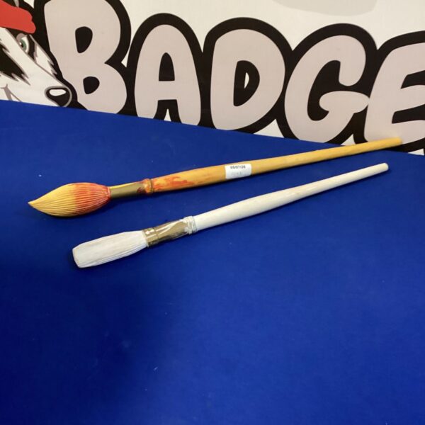 Two large wooden display paint brushes for decorative use.