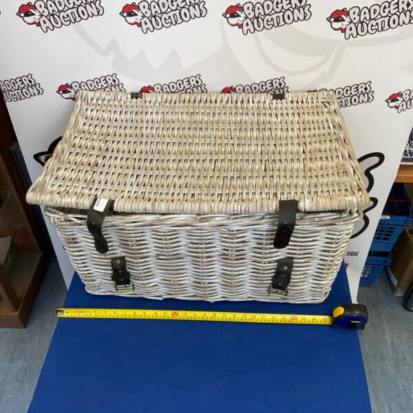 Large whitewashed wicker basket for storage and display.
