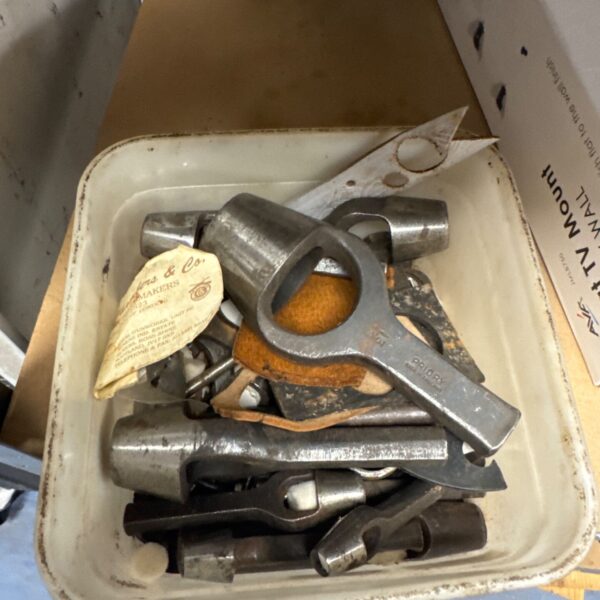 Assorted vintage leather and gasket punches in a tub.