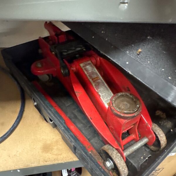 Red Liftmaster 2 ton trolley jack in a workshop setting.