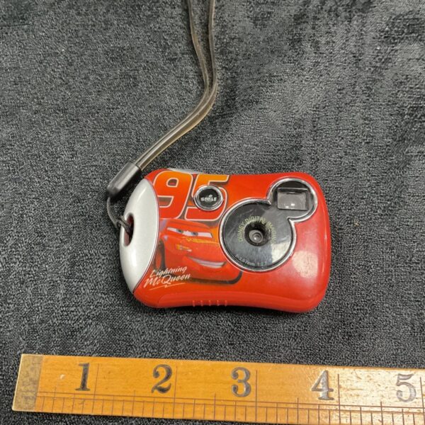 Front view of red Lightning McQueen digital pocket camera with strap.