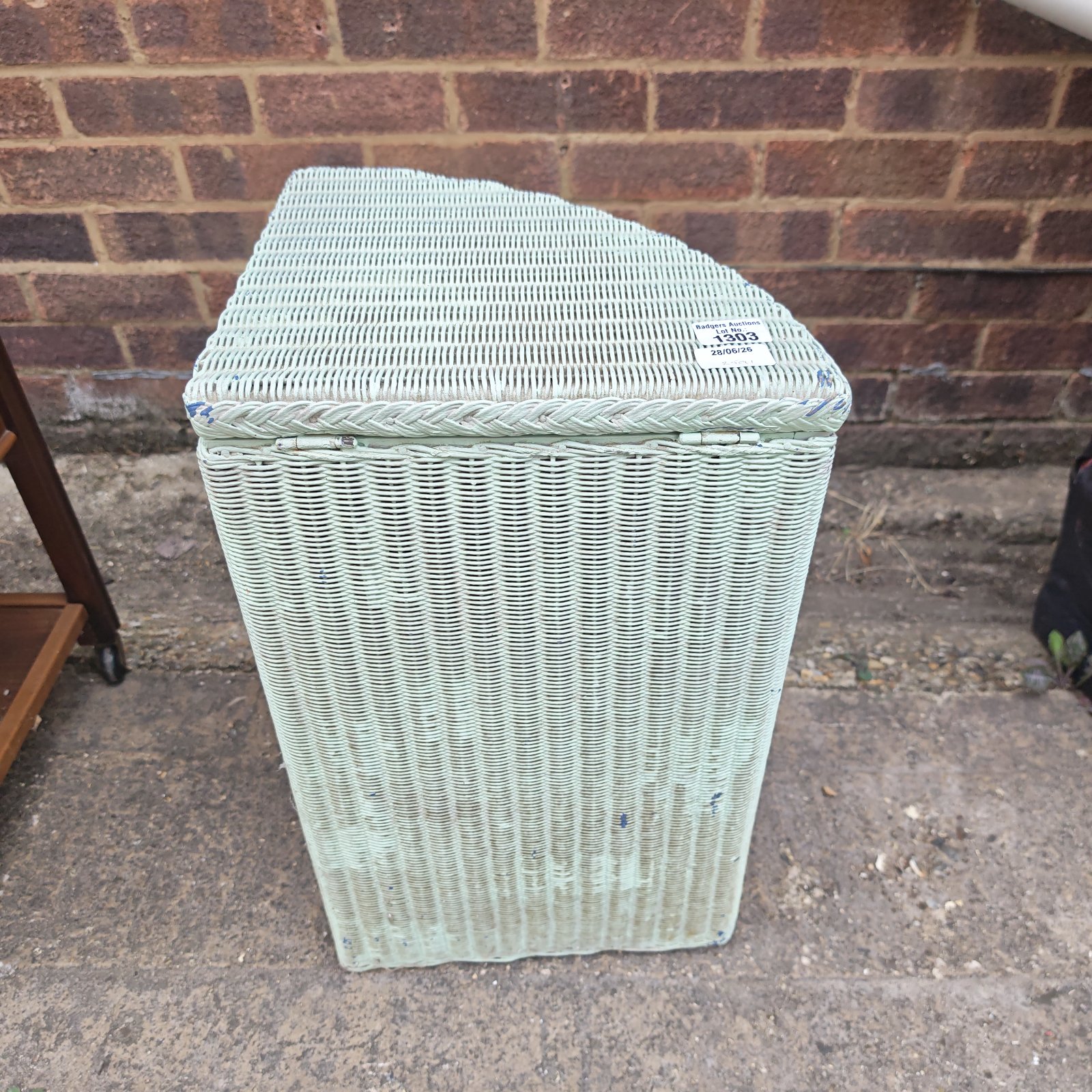 Vintage pale green Lloyd Loom wash basket for laundry storage.