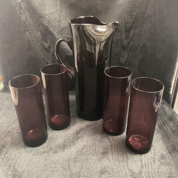 Four purple glasses with purple jug