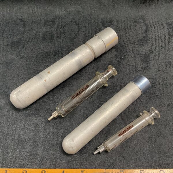 Two Vintage Super Eva Glass Syringes in metal tubes