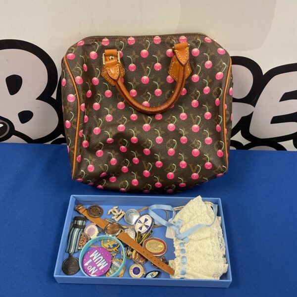 Louis Vuitton style handbag with vintage enamel badges and collectables.