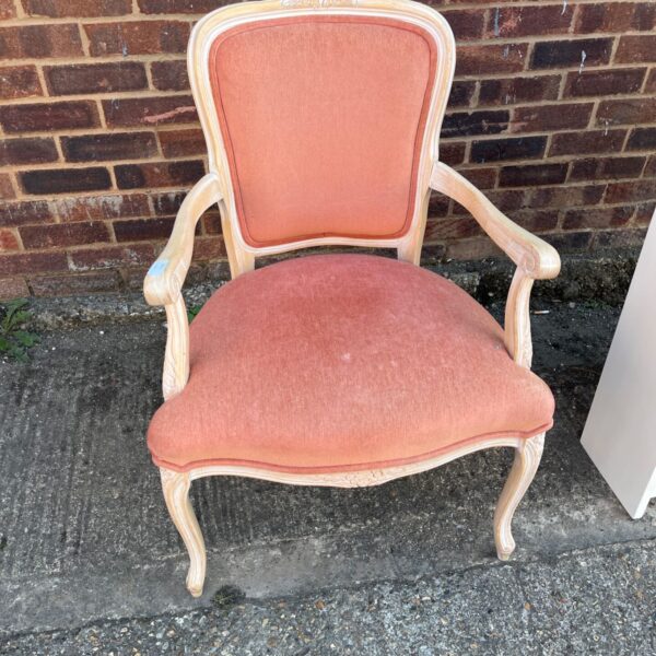 Elegant pink Louis XV fauteuil armchair with carved wooden frame.
