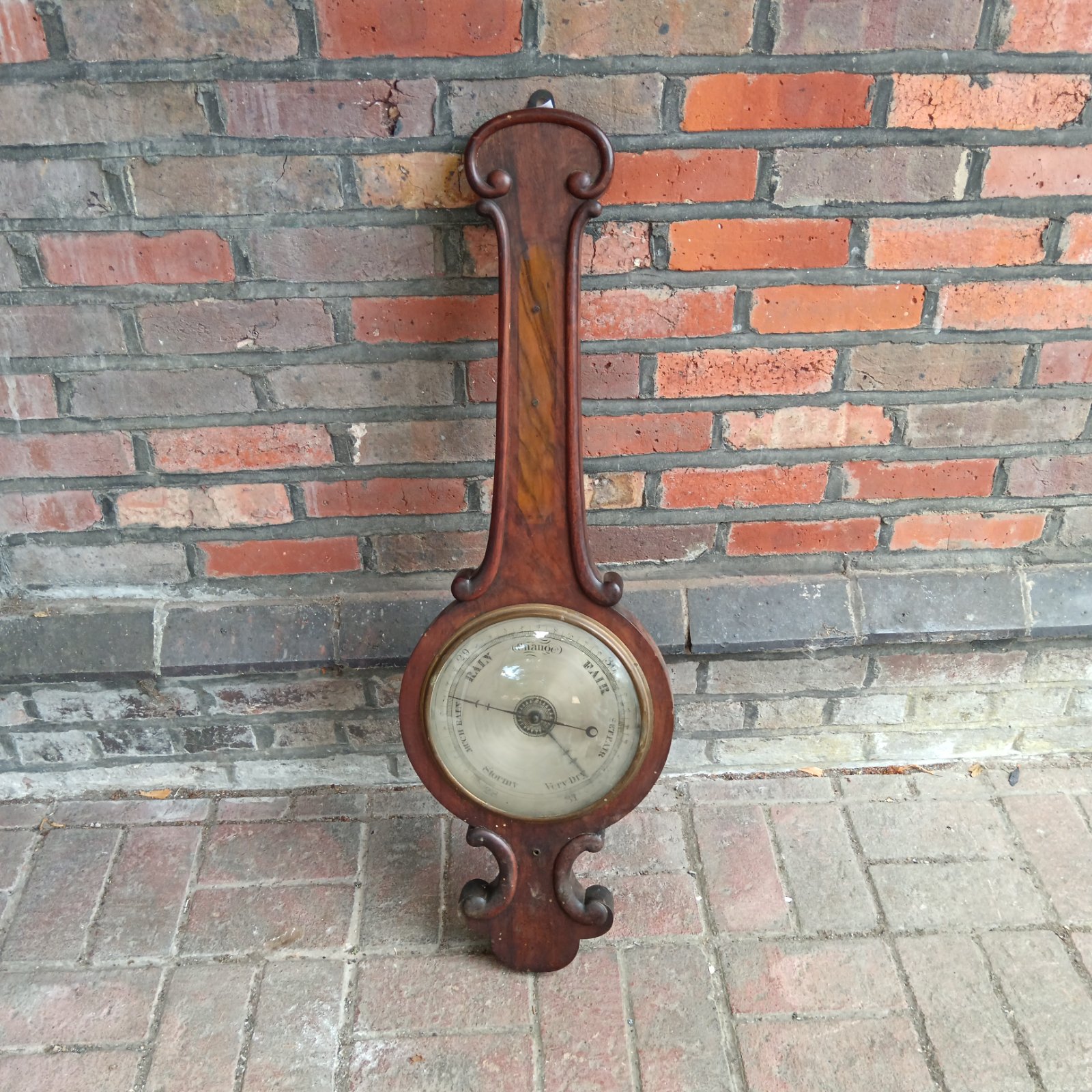 Antique mahogany barometer with dial showing fair weather.