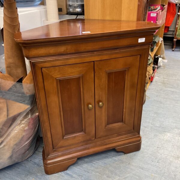 Reproduction mahogany corner cupboard with a single door.