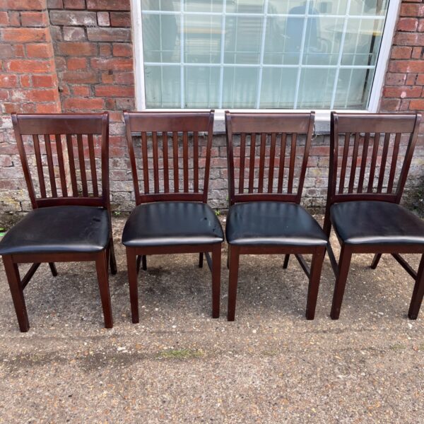 Set of four mahogany dining chairs with faux leather seats.