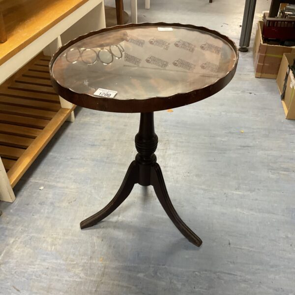 Vintage mahogany wine table with glass top and pie crust edge.