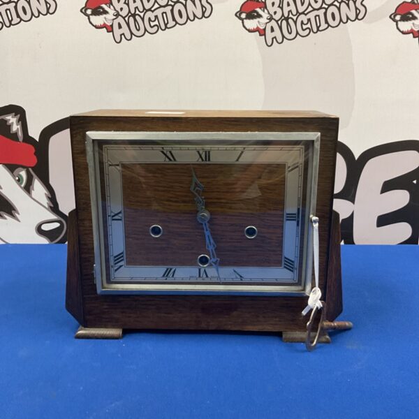 Vintage mantle clock with Roman numerals and wooden case.