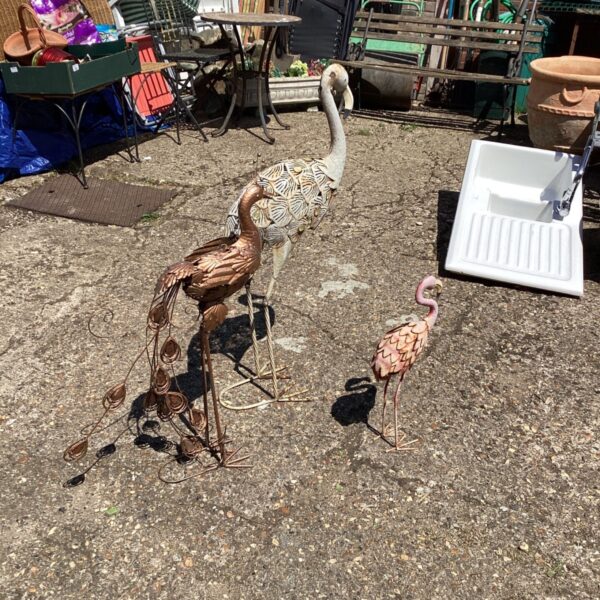 Rusted metal garden bird ornaments set for outdoor decoration.