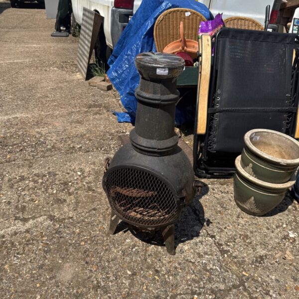 Dark metal garden chiminea with mesh front, ideal for outdoor heating.