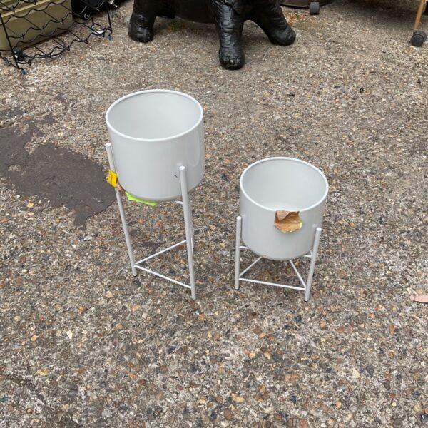 Pair of vintage metal plant stands for displaying flowers.