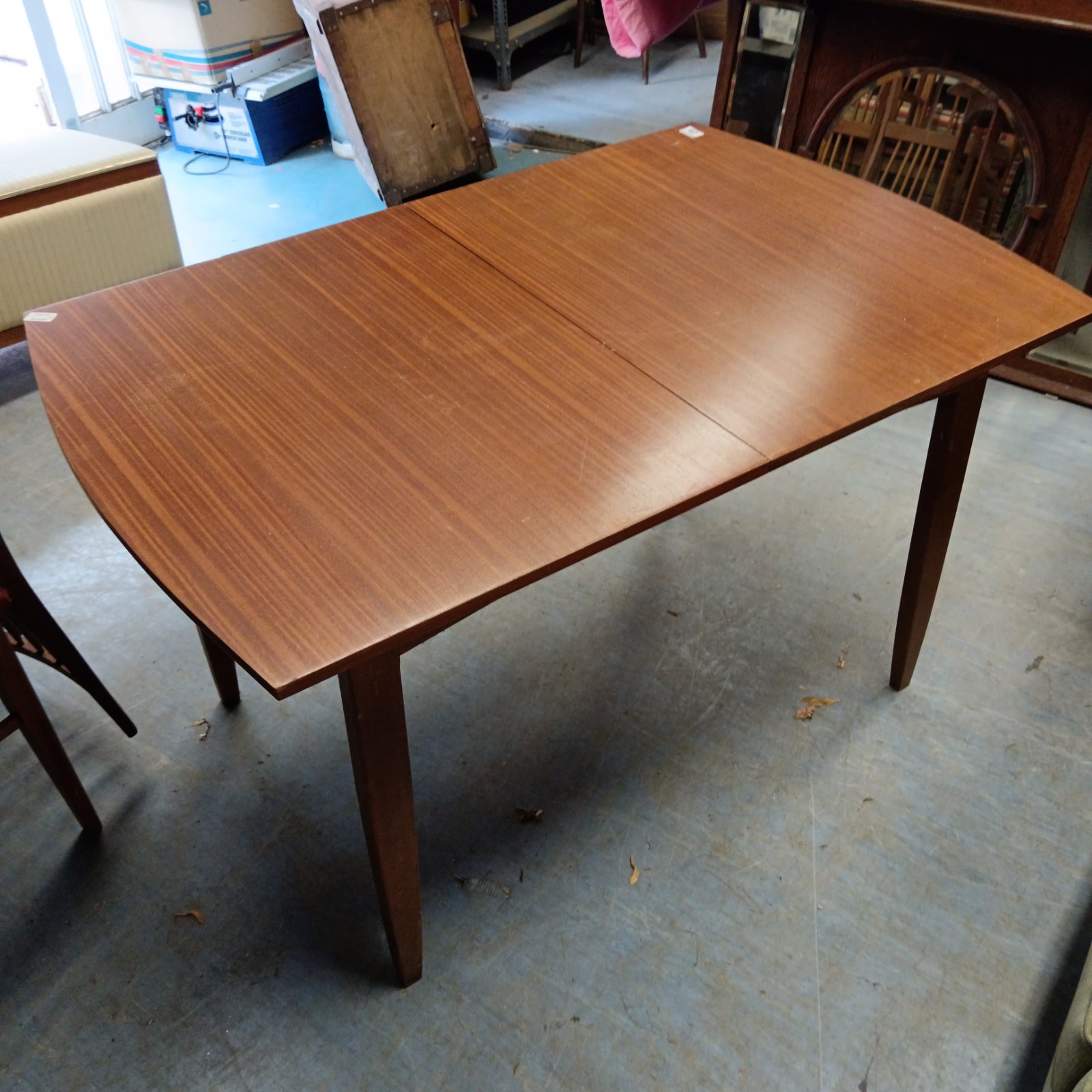 Vintage mid-century extending dining table in warm wood tone.