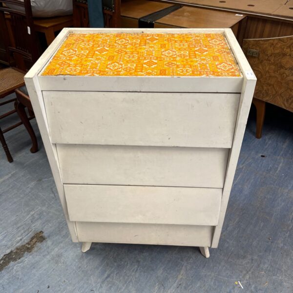 White mid-century chest of drawers with a retro patterned top.