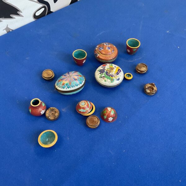 Vintage miniature pill pots collection with colourful designs.