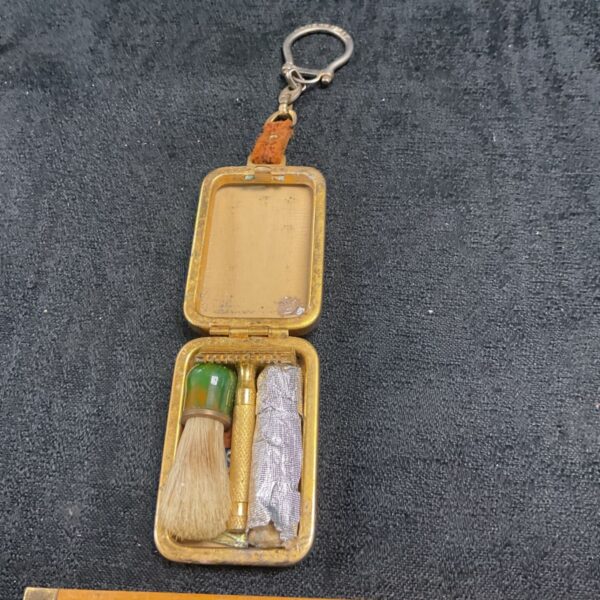 Vintage miniature shaving set keyring with brush and blade.