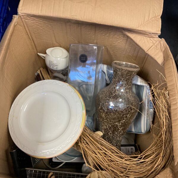 Mixed lot of home decor items in a cardboard box.