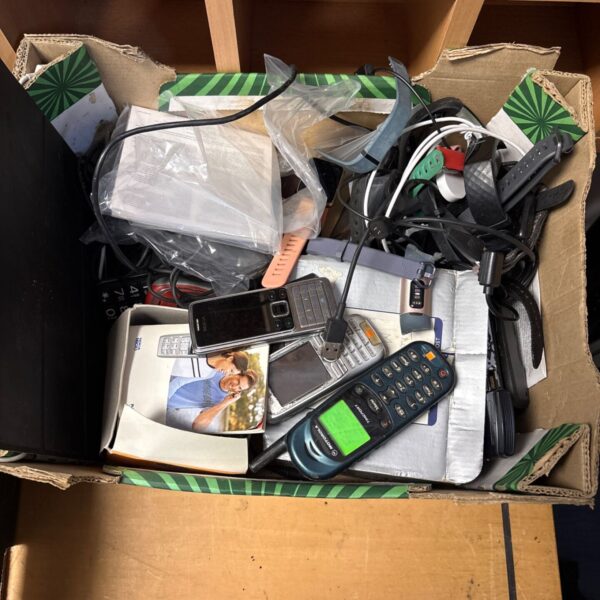 Mixed lot of mobile phones and a Fitbit smartwatch for sale.