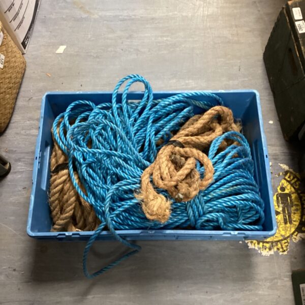 Crate filled with mixed rope, including blue and sisal cordage.