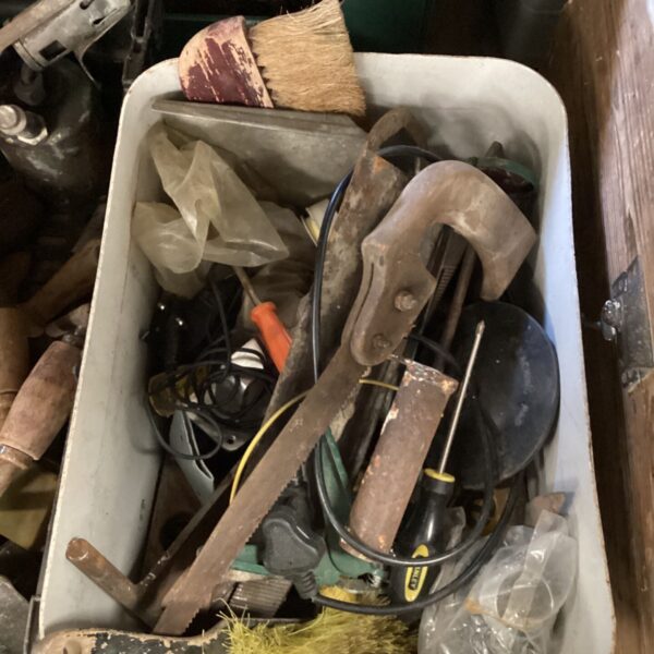 Mixed tool lot with brushes, saw, and screwdriver.
