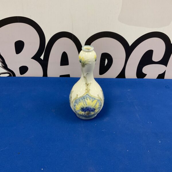 Antique William Moorcroft cornflower vase with blue background.