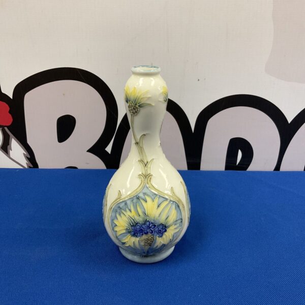 Vintage Moorcroft style vase with cornflower design on blue background.