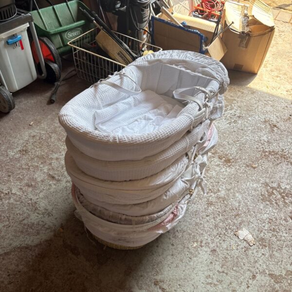 Stack of new Moses baskets for baby nursery.