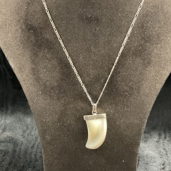 Silver necklace with a sculpted mother of pearl tooth pendant.