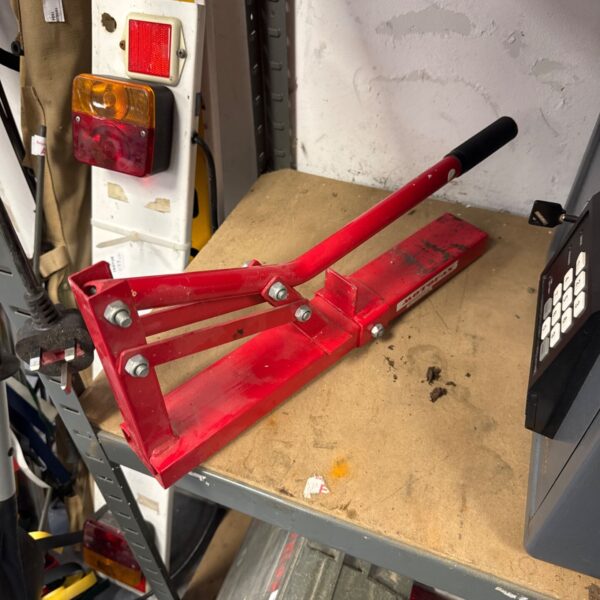 Red Motofax motorcycle tyre bead breaker tool for wheel changes.