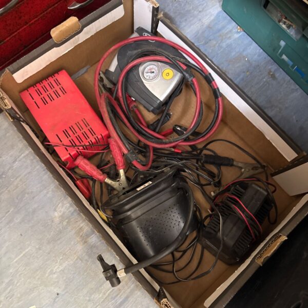 Box of motoring accessories including a tyre inflator and battery charger.