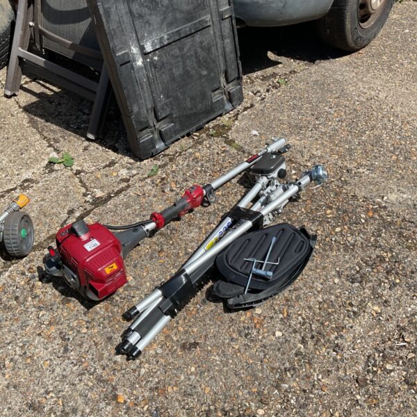 Used Mountfield petrol strimmer with attachments for garden maintenance.
