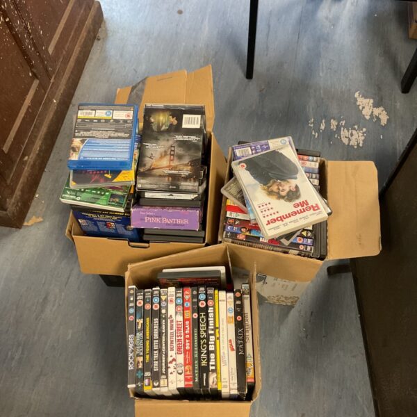 Large lot of assorted movie DVDs in a cardboard box.