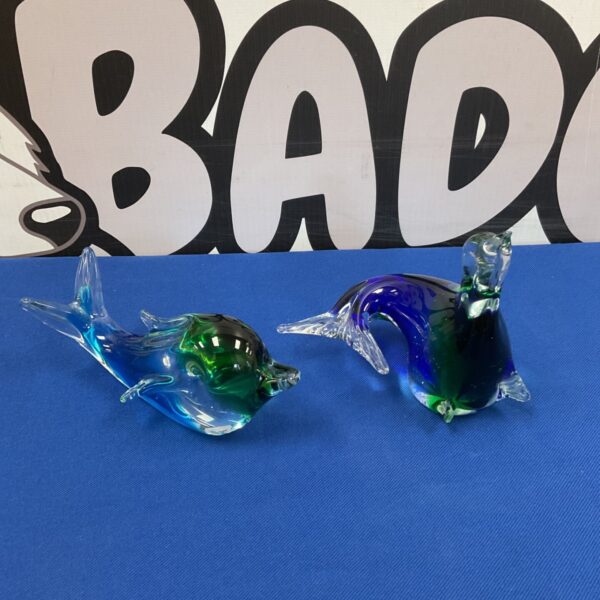 Vibrant Murano glass dolphin and sealion paperweight sculptures.