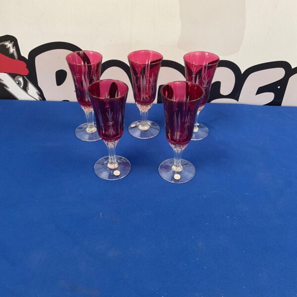 Five ruby red Murano wine glasses displayed together.