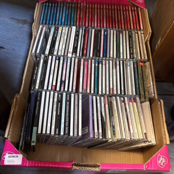 Mixed music CD collection in a cardboard box.
