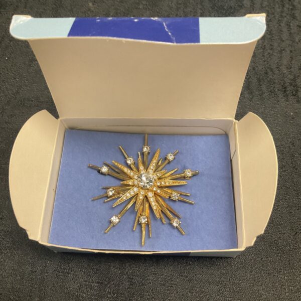 Vintage Nina Ricci Avon starburst brooch in original box.