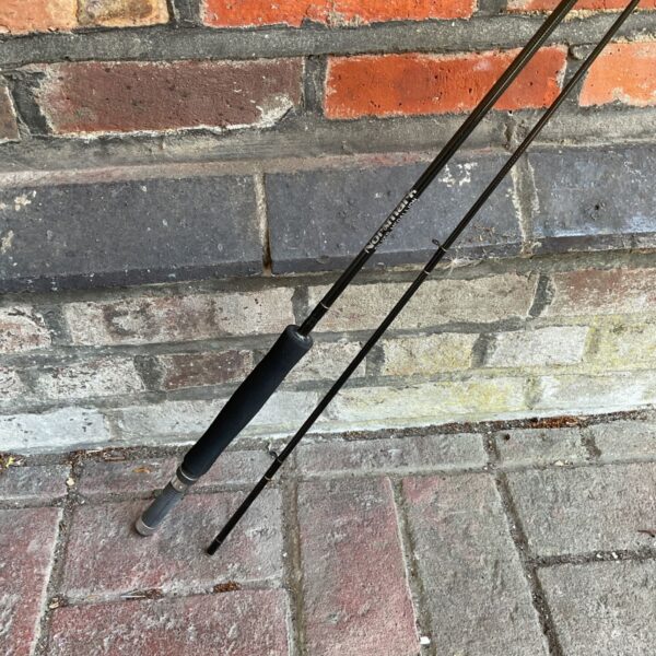 Vintage Normark fly fishing rod displayed on brickwork.