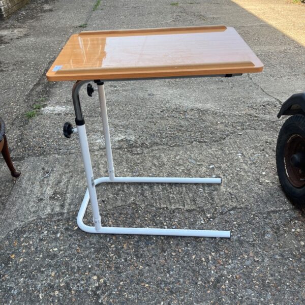 White framed overbed table with beech effect top.
