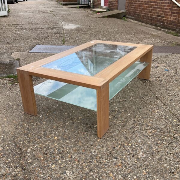 Vintage oak framed glass top coffee table in a home setting.