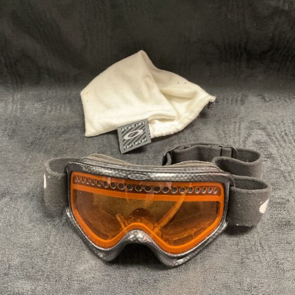 Vintage Oakley ski goggles with orange lens for snow sports.