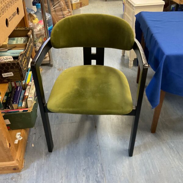 Stylish olive green velvet designer chair with black metal legs.