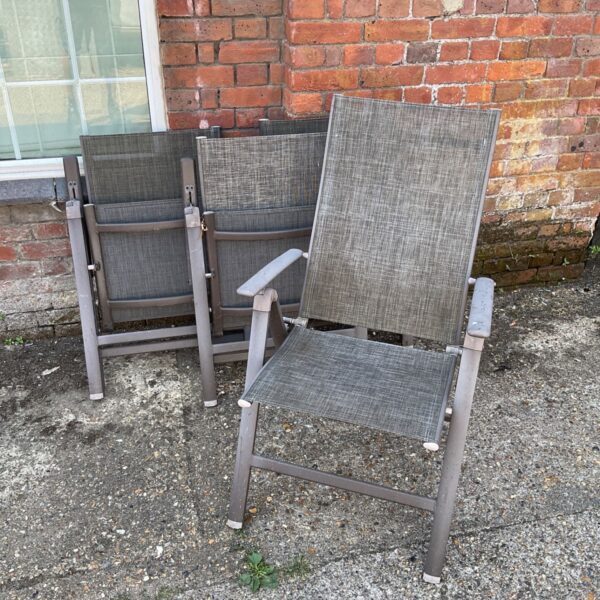Set of four Amazon Basics outdoor folding chairs in a garden setting.