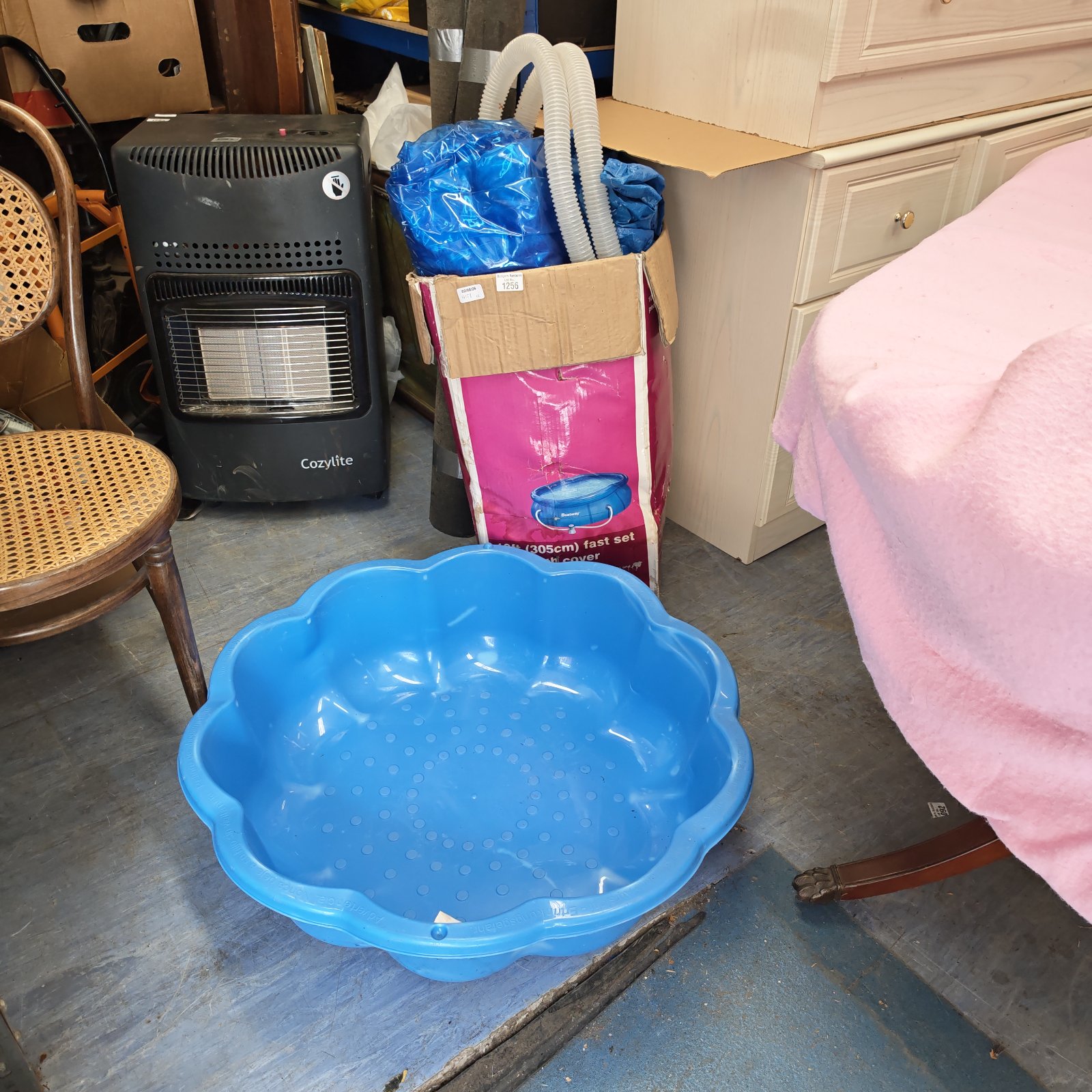 Blue paddling pools set for babies and children in a garden setting.