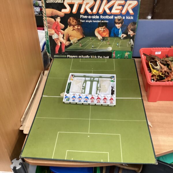 Vintage Parker Striker football game with green playing surface.
