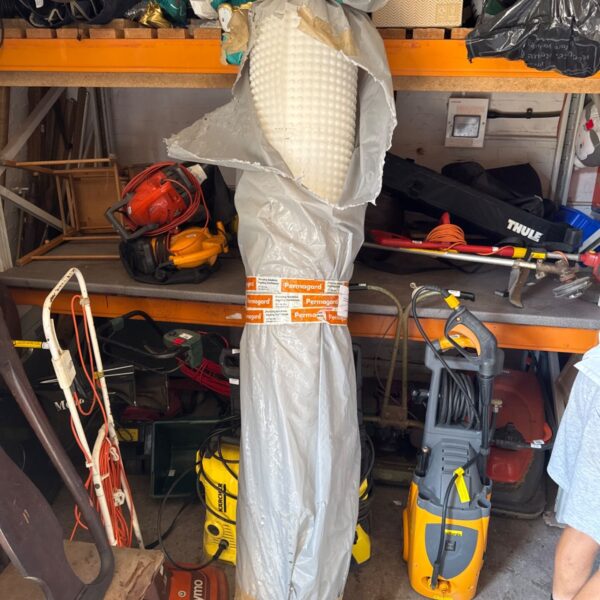 Large roll of Permagard floor protector in a cluttered garage.